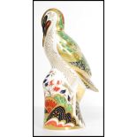 A Royal Crown Derby paperweight, Green Woodpecker, silver stopper and stamped to base. Measures 17