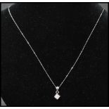 A 9ct gold and diamond pendant necklace strung with a diamond pave set pendant  on a white gold