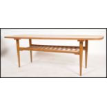 A Danish inspired mid century teak wood rectangular coffee table being raised on tapered legs with