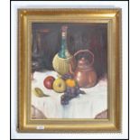 A framed 20th century oil on canvas still life painting depicting fruit at the foot of a brass