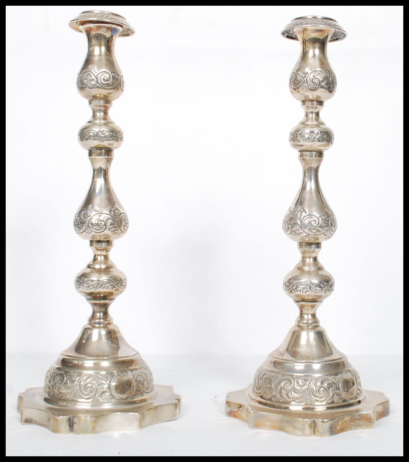 A large pair of Edwardian silver hallmarked London tall candlesticks with shaped terraces and shaped