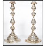 A large pair of Edwardian silver hallmarked London tall candlesticks with shaped terraces and shaped