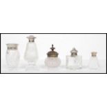 A collection of vintage early 20th century cut glass perfume / atomizer bottles many with silver