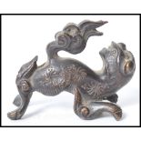 A 19th century Chinese bronze figurine of a temple lion dog of Fu having a flaming tail. Measures