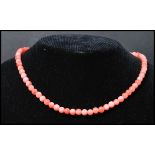A vintage angel skin coral necklace. Each bead carved and strung set to a gilt barrel clasp.