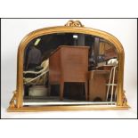 A Victorian style large dome top overmantel mirror of arched form having plinth base, gilded resin