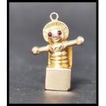 A 9ct gold Jack In The Box charm having ruby stone eyes. Unmarked but tests as 9ct gold, eyes test