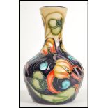 A Moorcroft ceramic vase tube lined decorated with flowers in the Celtic Web pattern complete in