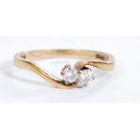 A hallmarked 9ct gold and diamond crossover ring set with two diamonds of approx 10pts each.