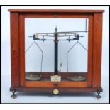 A pair of early 20th century mahogany cased scientific scales. The glass case with inset scales on