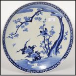 A 19th century blue and white Chinese ceramic charger plate depicting flowers and birds. Measures