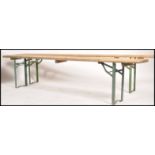 A pair of vintage industrial German made festival trestle table benches, pine seat top with