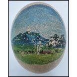 A 19th / 20th century Ostrich egg with a hand painted mountain scene to the front of possibly