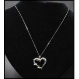 A 14ct white gold and diamond pendant necklace strung with a diamond set heart shaped pendant  on