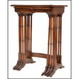 An Edwardian mahogany quartetto nest of tables being raised on faux bamboo supports with splayed