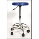 A contemporary chrome and plastic operators - surgical chair. The blue plastic swivel seat over