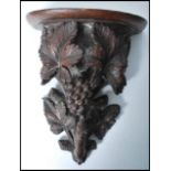 A 19th century Black Forest carved pine wall bracket, with shaped and moulded shelf, supported by
