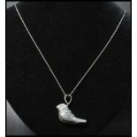 A 925 silver pendant necklace strung with a figural whistle pendant of a bird strung on a rope twist