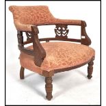 A late Victorian mahogany tub chair - armchair being raised on turned legs with overstuffed seat and