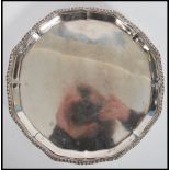 A silver hallmarked salver raised on claw and ball feet bearing London hallmarks, date letter e
