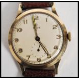 A vintage 20th century Tudor Rolex wrist watch having a silvered dial with gilt numerals, faceted