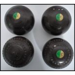 A set of four vintage 20th century Lignum Vitae lawn bowls, applied makers plaque to all.