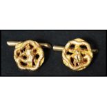 A pair of vintage 18ct gold Chinese cuff links in the form of Chinese dragons with bamboo t bars.