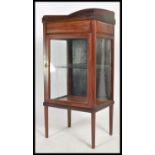 A mahogany 20th century bijouterie upright pedestal display cabinet raised on squared legs with