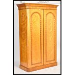 A 19th century Victorian satin birch wood double wardrobe compactum. Raised on a plinth base with