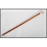 A vintage 20th century walking stick cane. The tapering wooden shaft having a silver stamped