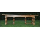 A good 20th century heavy and large oak refectory dining table being raised on turned baluster