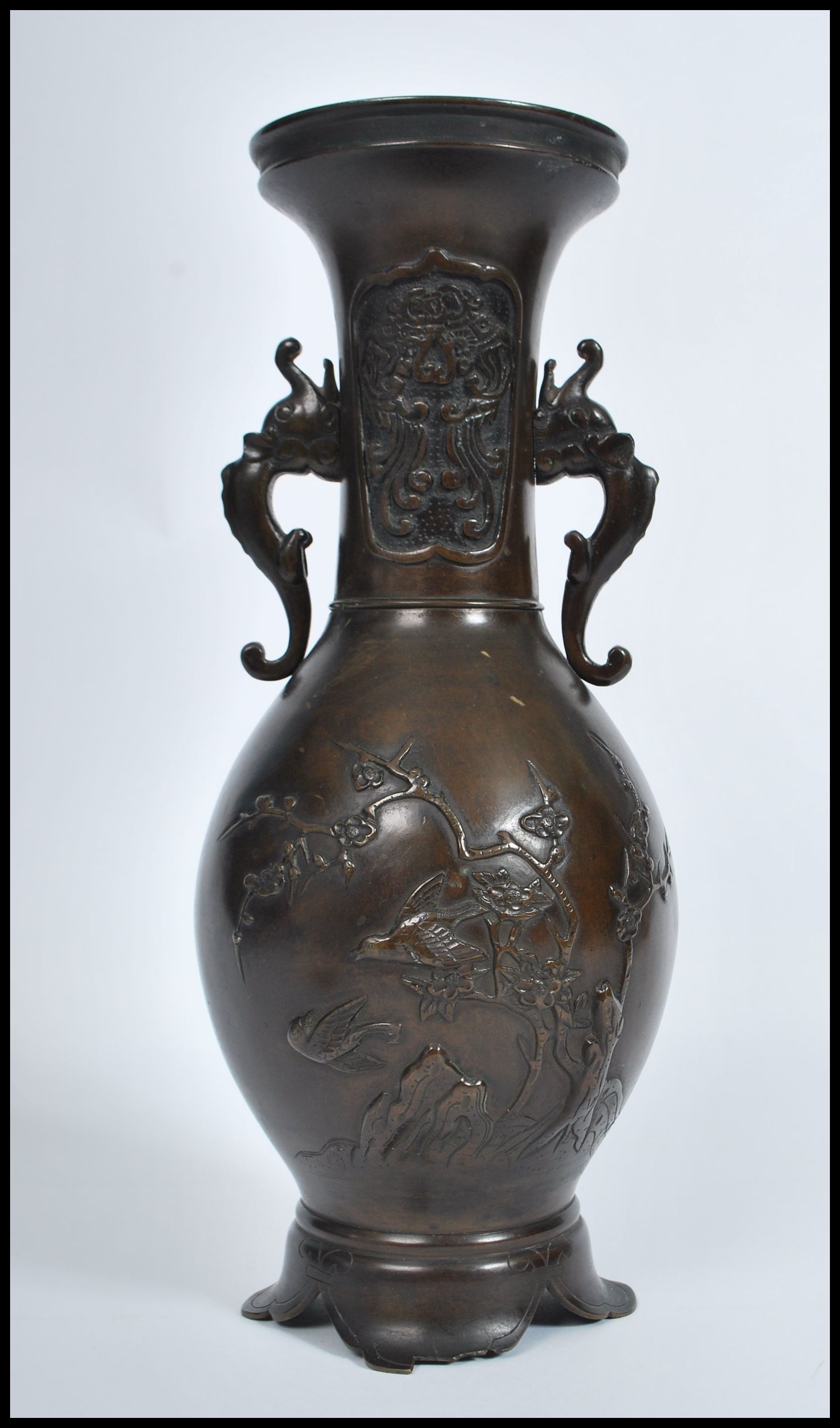 A Meji period Japanese bronze two handled vase of typical baluster form, decorated in relief with