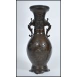 A Meji period Japanese bronze two handled vase of typical baluster form, decorated in relief with