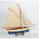 A vintage 20th century scratch built model of a sailing boat raised on the original wooden display