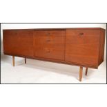 A 1970's Avalon teak sideboard of good proportions being raised on turned legs with a central bank