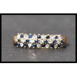 A hallmarked 9ct gold sapphire and diamond cluster ring. Hallmarked London. Weight 2.6g. Size N.