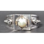 A signed Taxco Mexican modernist silver bangle bracelet set with a pearl having a clip clasp. Marked