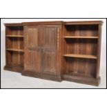 An early 20th century oak breakfront bookcase cabinet. Raised on a plinth base with upright bookcase