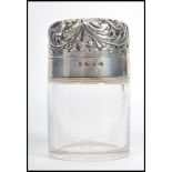 A 19th century Victorian silver hallmarked glass perfume bottle. The scrolled hinged lid opening