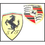 A vintage style cast metal point of sale advertising wall plaques for Ferrari and Porsche both