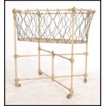 A 19th century cast iron painted childs crib. The stand with castors to the base having a strung