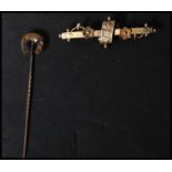 A 19th century 15ct gold stick pin along with a 9ct gold bar brooch. The pin with horse shoe to
