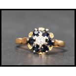 A hallmarked 18ct gold diamond and sapphire cluster ring having a central illusion cut diamond wit a