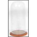 A 19th century Victorian large glass dome raised on a circular wooden plinth base. Perfect for