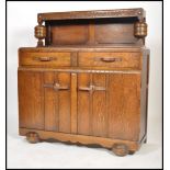 A 1930's Art Deco oak buffet / sideboard. Raised on shaped feet with cupboard above having stage