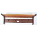 A vintage mid 20th century retro teak wood coat rack of angular  form having a railed rack above