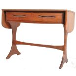 A 1970's retro G-Plan teak wood drop side writing table being raised on splayed legs with