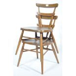 A pair of rare mid century beech and elm wood Ercol ' Green Dot ' stacking chairs. Raised on