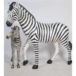 A stunning life-size resin painted grand scale adult female Zebra sculpture together with a Zebra