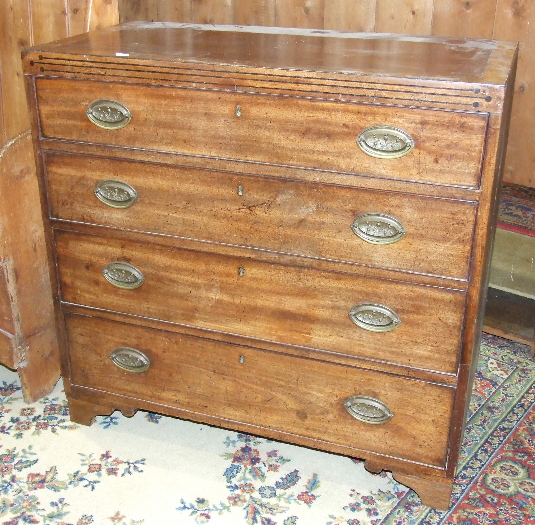 A Late-Georgian mahogany straight-front chest of four graduated long drawers, on later bracket feet,